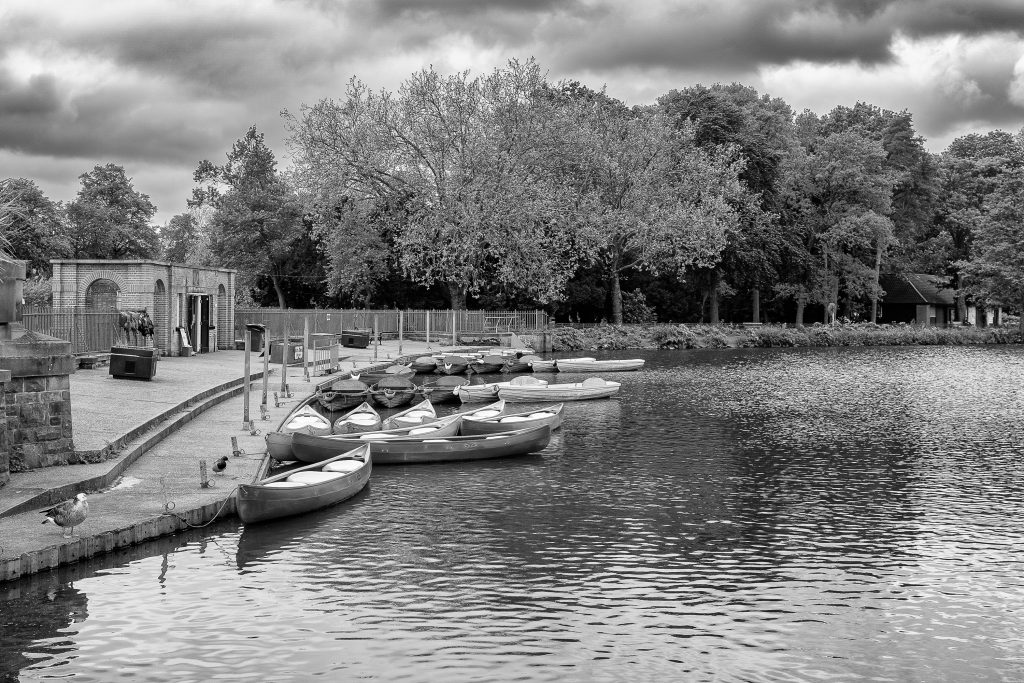 Small boats tied up ready for use at the bank of Highfields Lake, Nottingham.